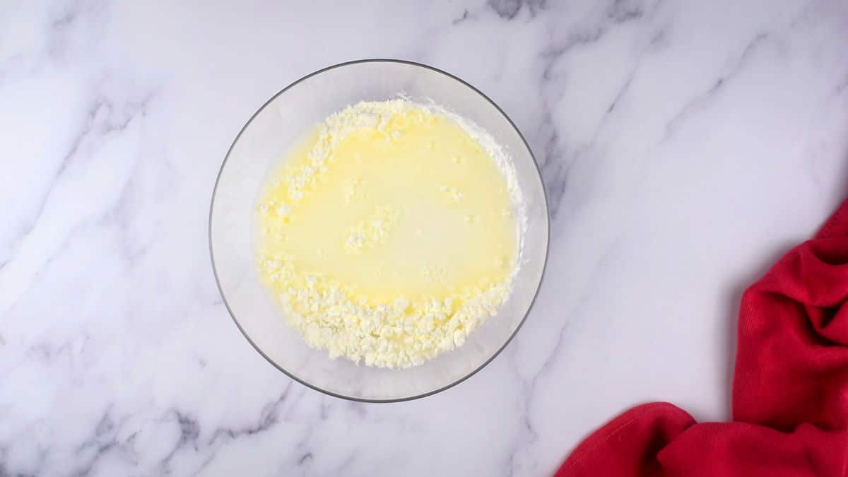 How to Make Mochi Ice Cream 3-2 Flour and water in small bowl on marble background.
