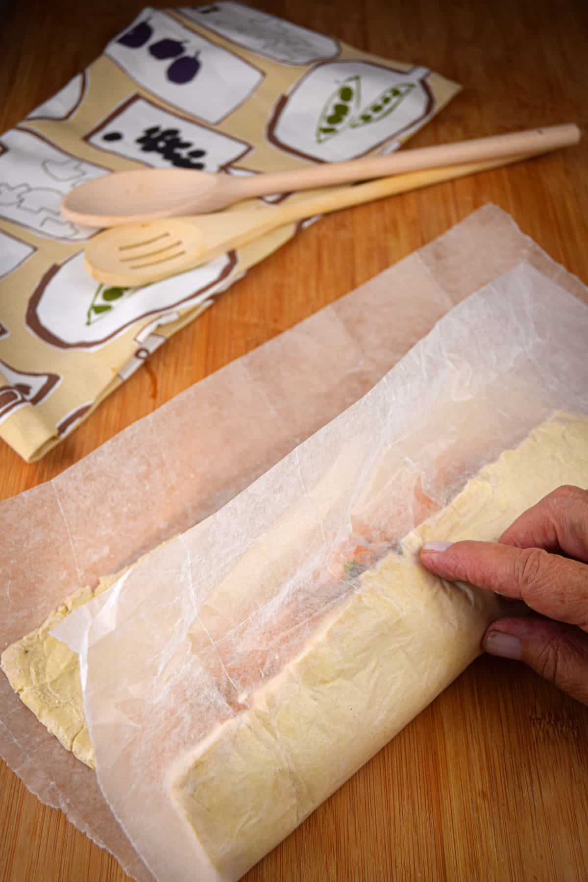 Unbaked sausage roll in parchment.