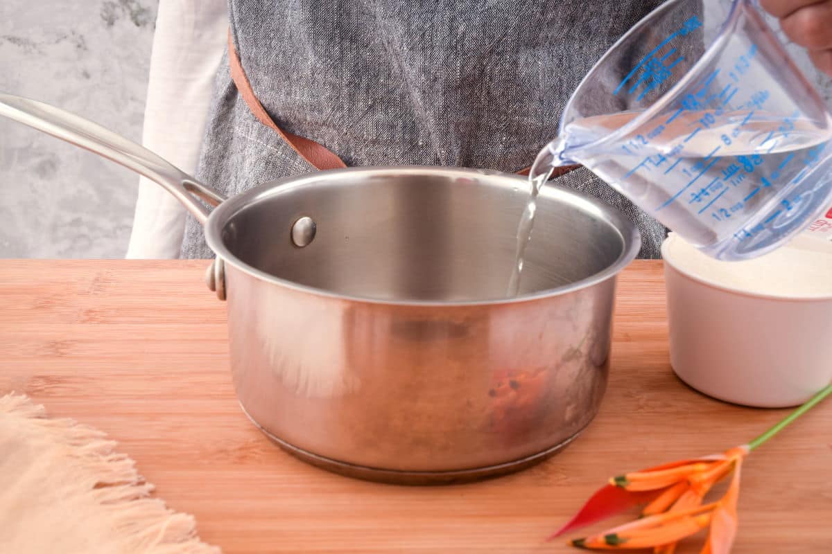 How to Make Simple Syrup Step 2 Water pouring into a pot on the counter.