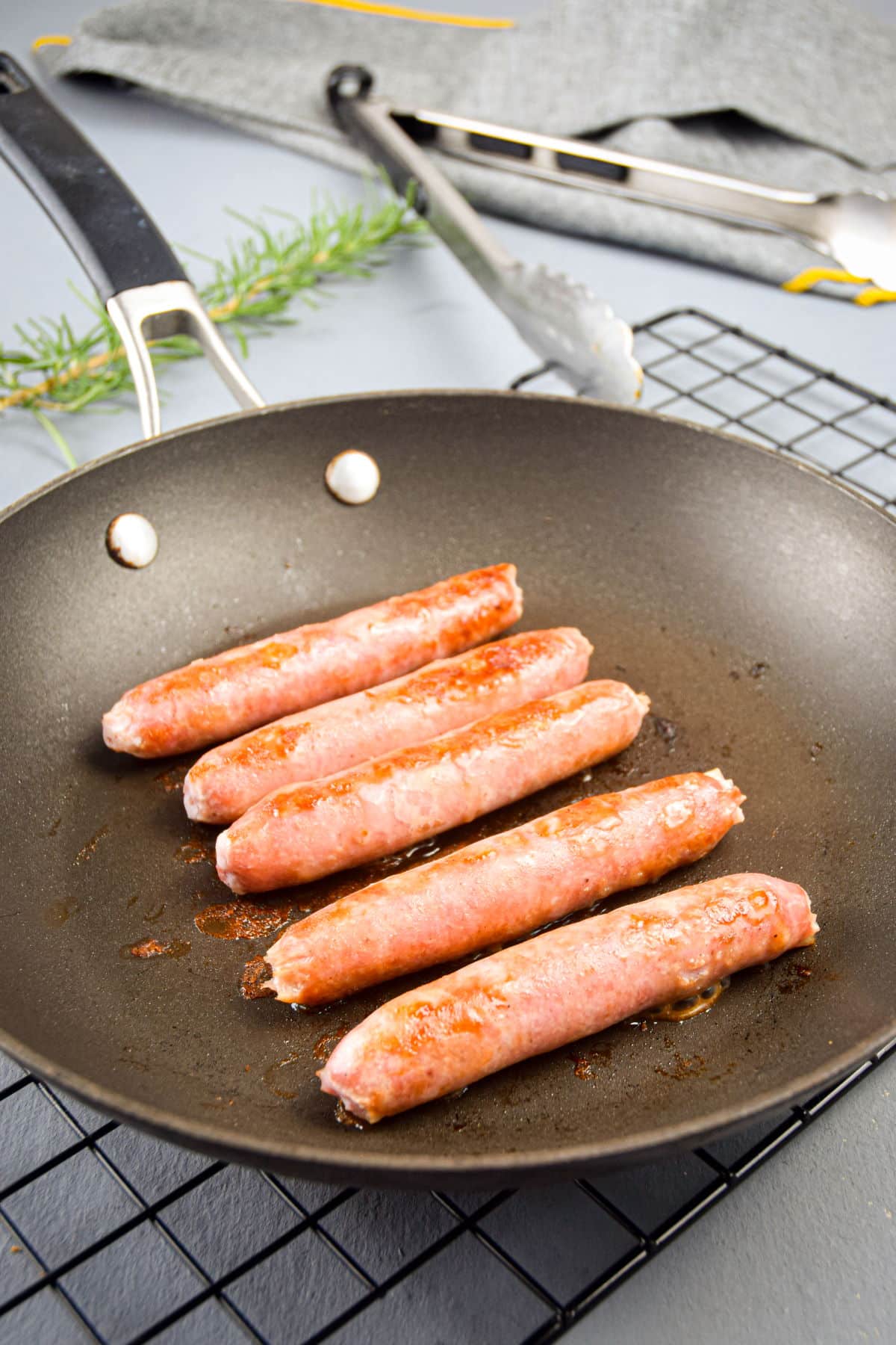 Golden English sausages in frying pan.