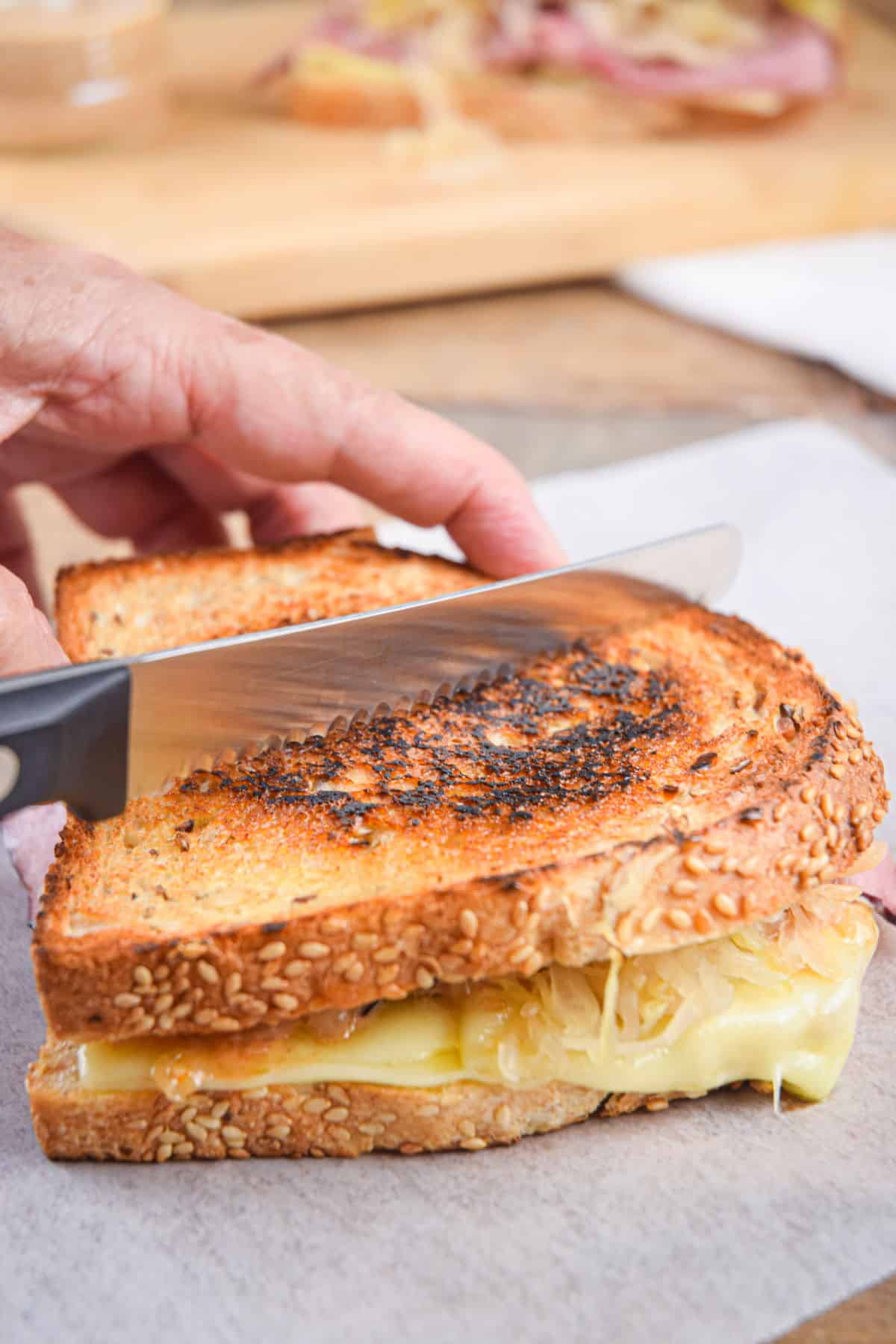 Knife slicing through a reuben sandwich.