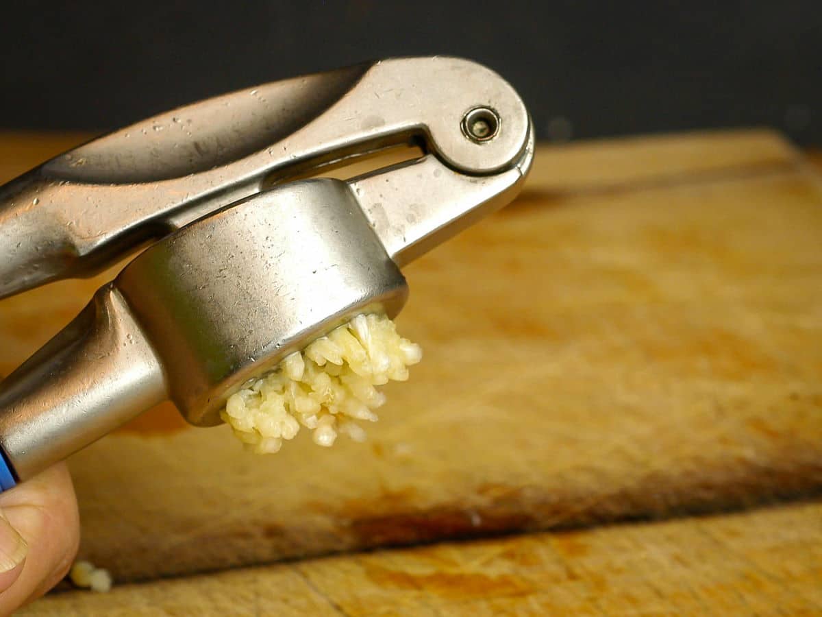 Garlic press with minced garlic.