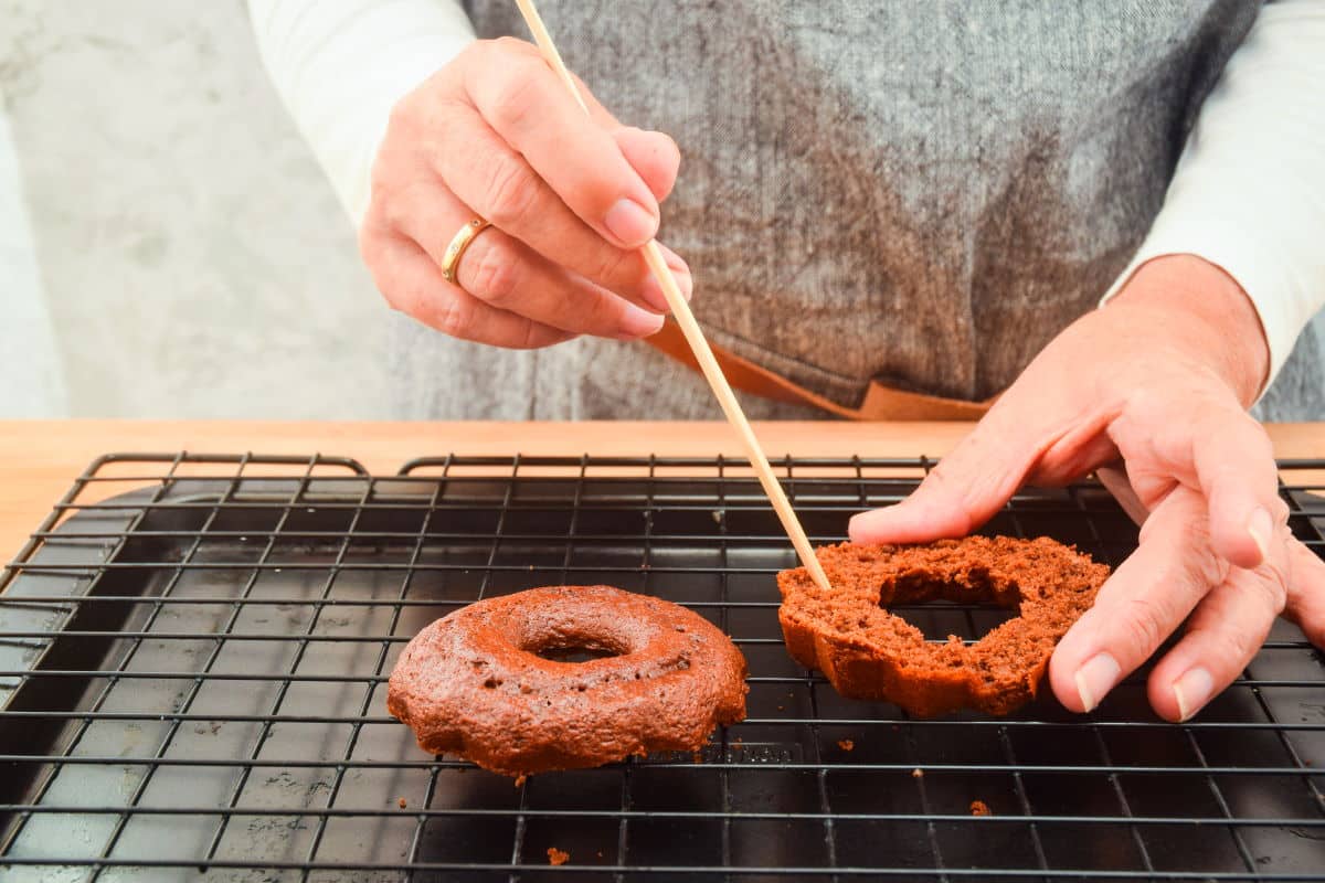 Small chocolate cake sliced in half with wooden skewer.