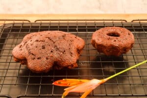 Soaked chocolate cakes on baking rack.
