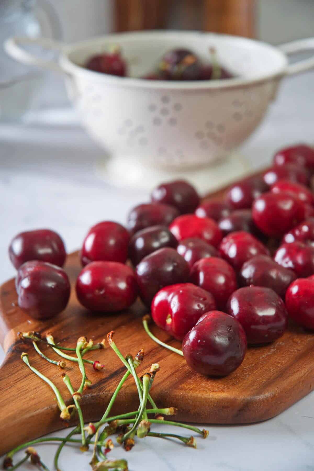 Stemless cherries on cutting board.