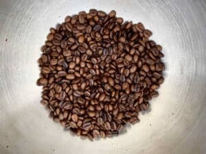 Coffee beans in metal bowl.