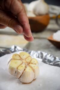 Head of garlic on parchment with salt.