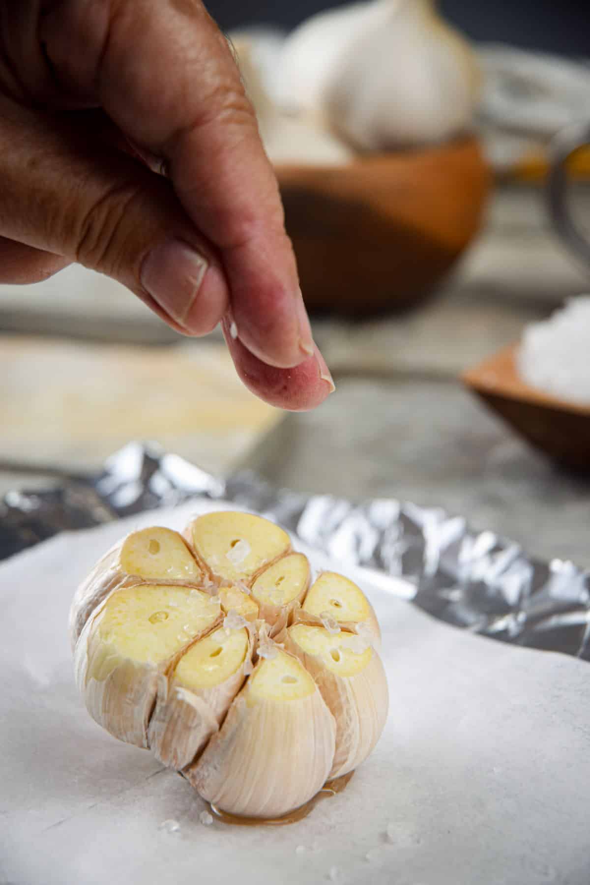Head of garlic on parchment with salt.