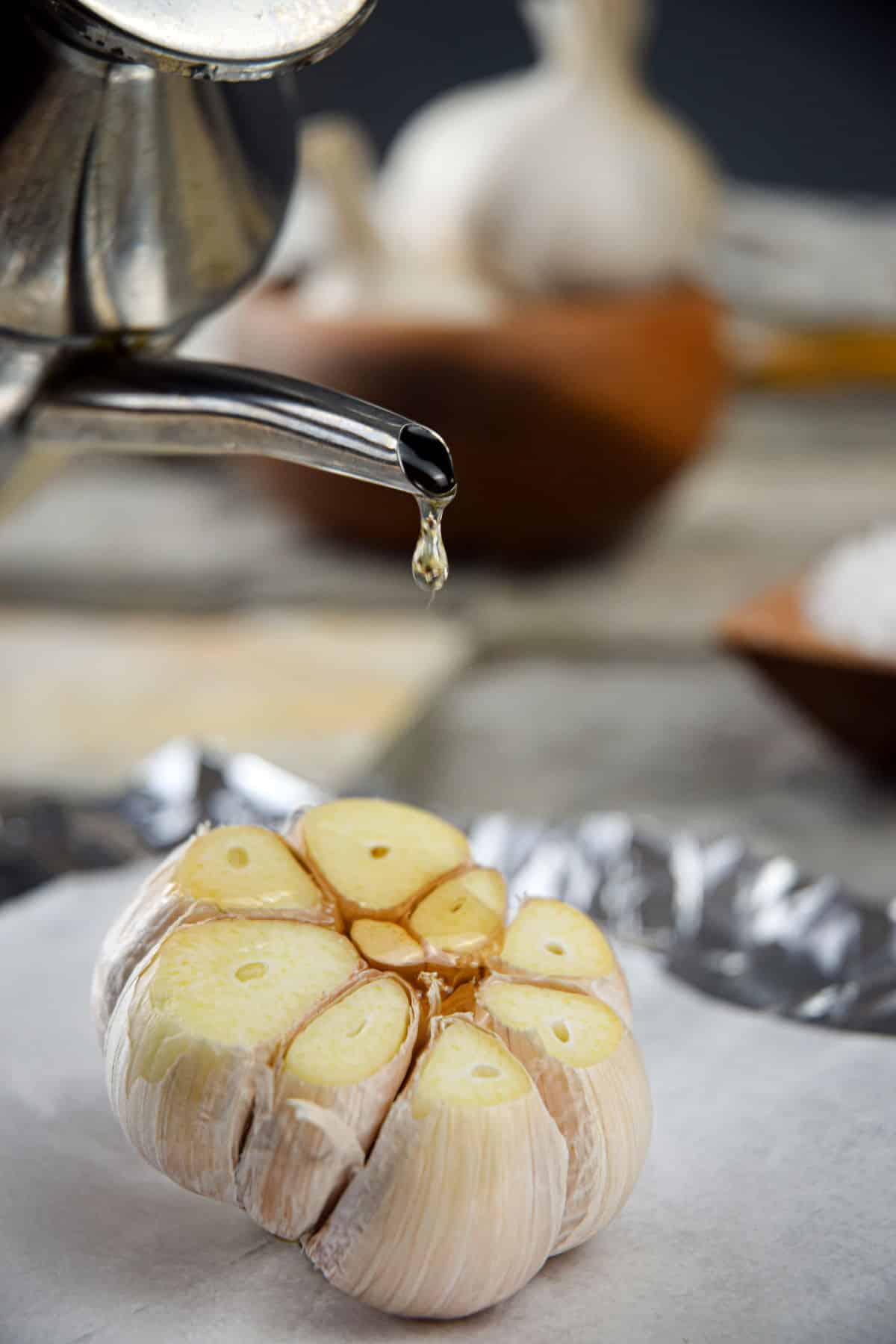 Head of garlic on parchment with oil.