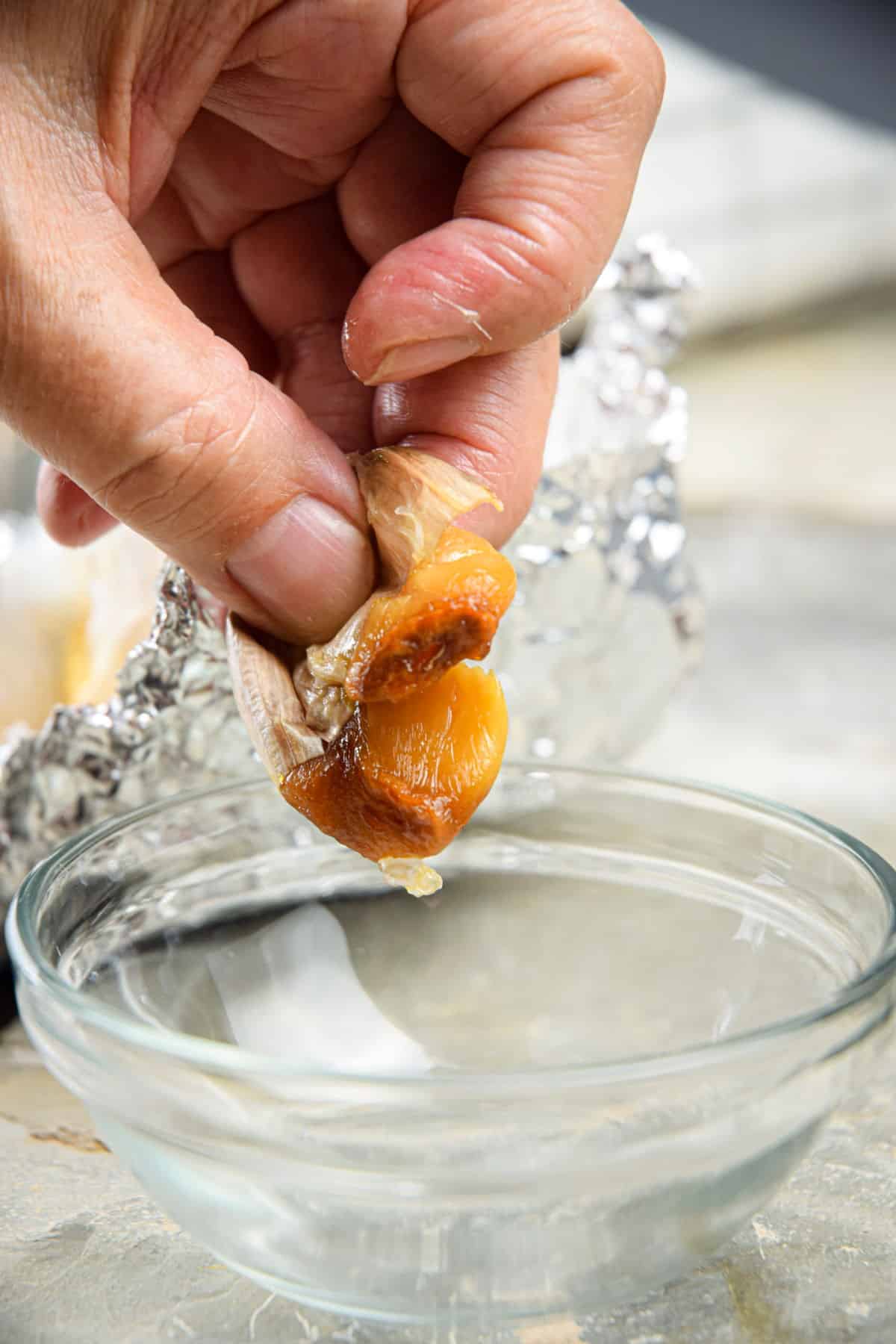 Roasted garlic clove squeezing out of peel.