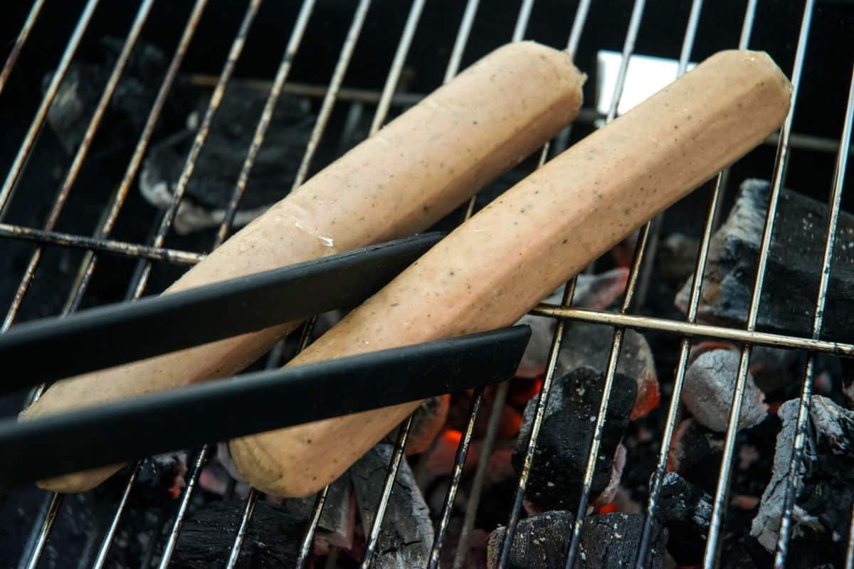 Raw Bratwurst sausages on the grill.