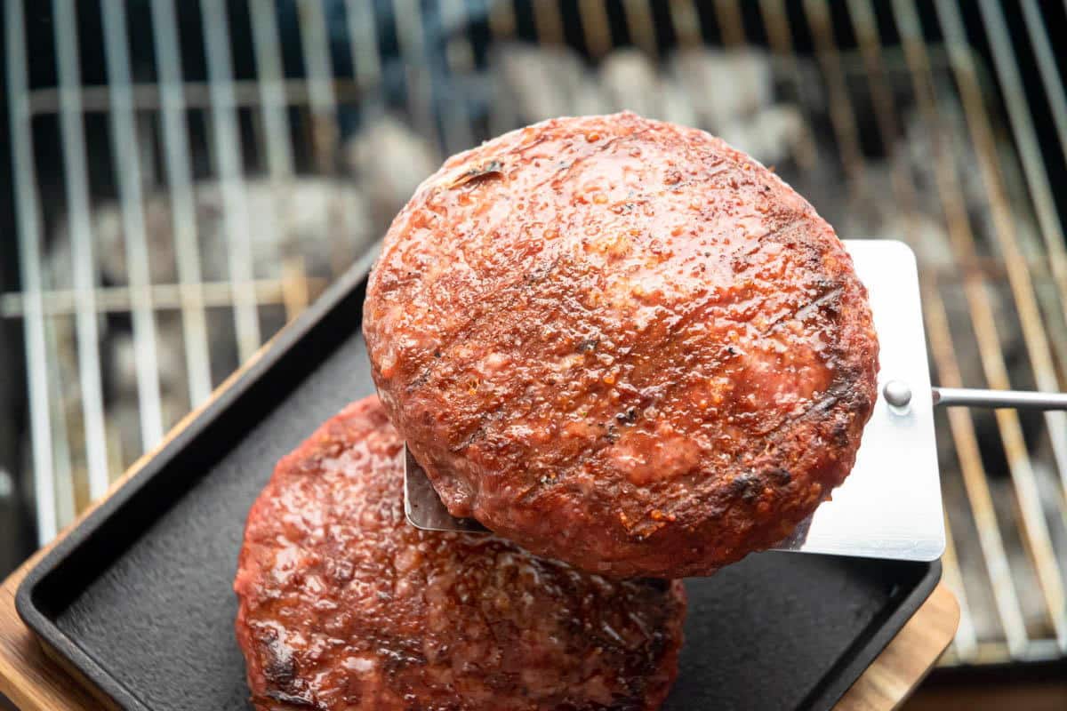 Cooked burger patties on a cast iron pan.