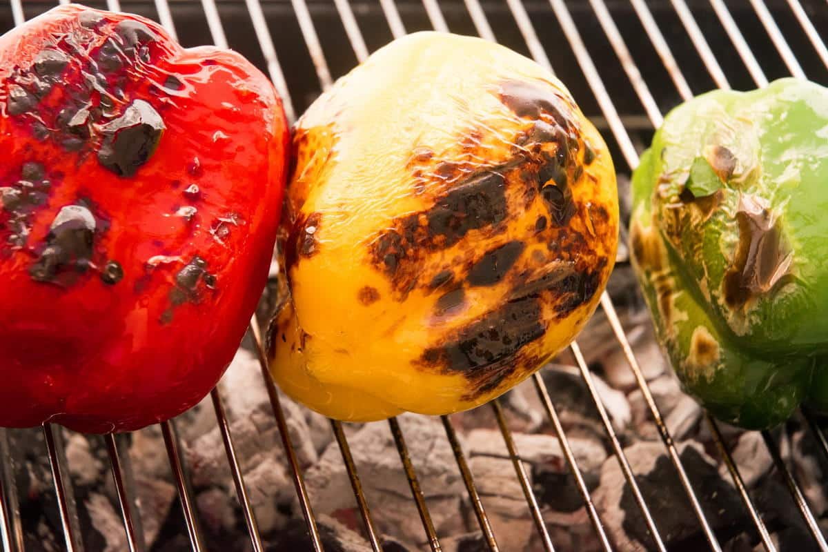 3 charred bell peppers on the grill.