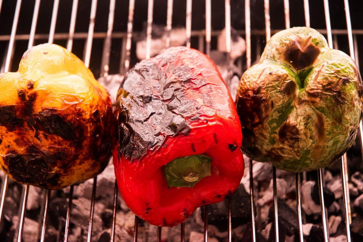 3 charred bell peppers on the grill.