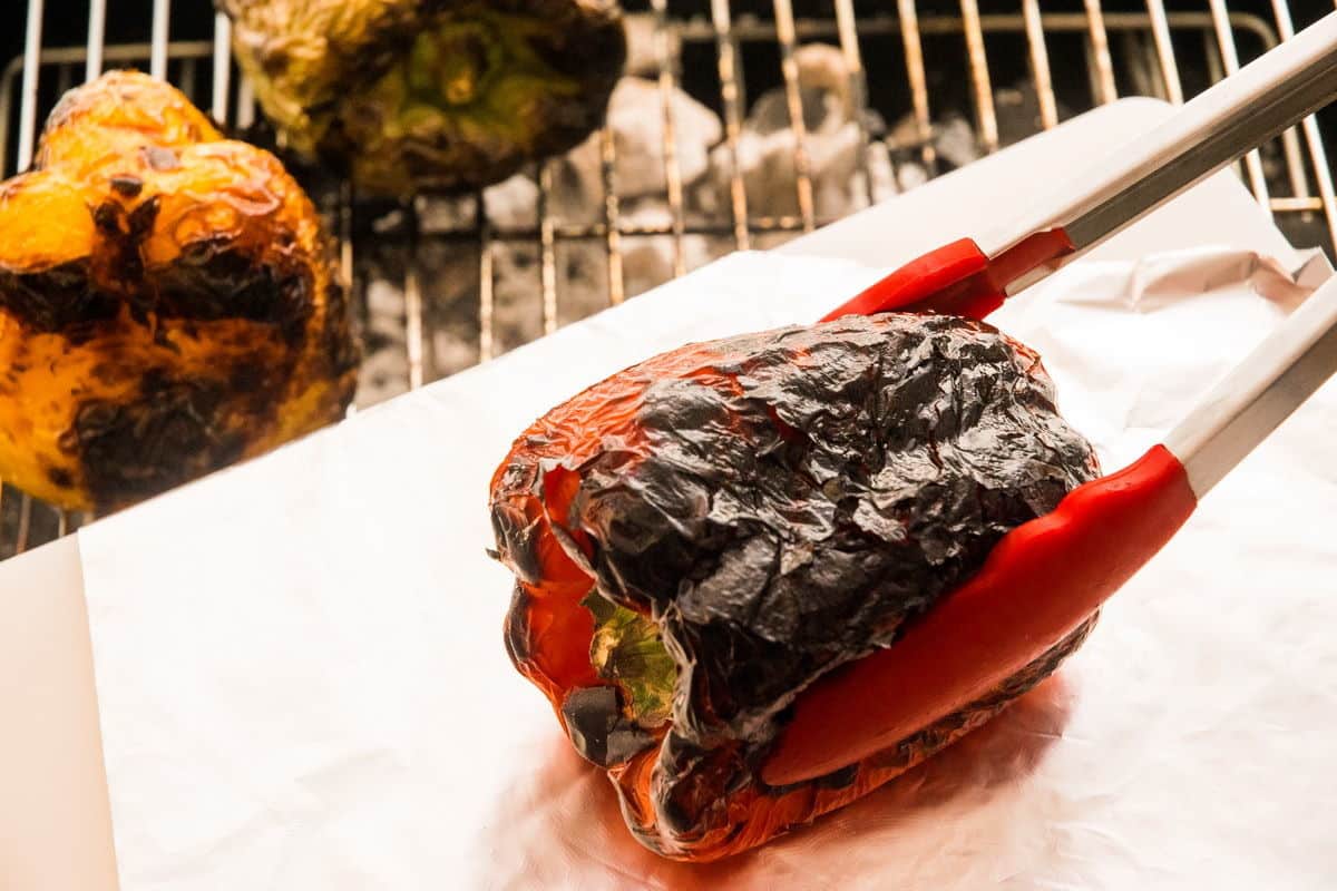 3 charred bell peppers on the grill.