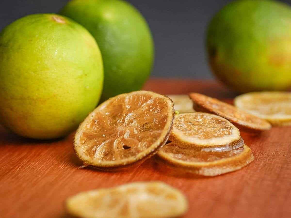 How to Candy Limes-Final 1 Sliced candied limes on wooden counter.