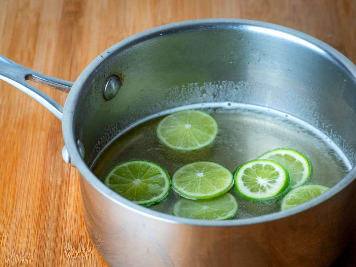How to Candy Limes - Step 4 Lime slices in a pot, wooden background.