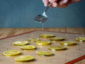 Candied limes sitting on a silicone mat.