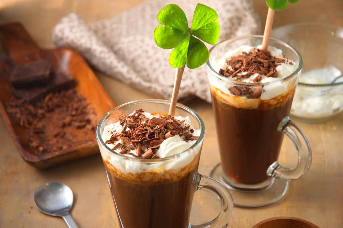 Irish coffee in coffee mug with 4 leaf clover and chocolate curls.