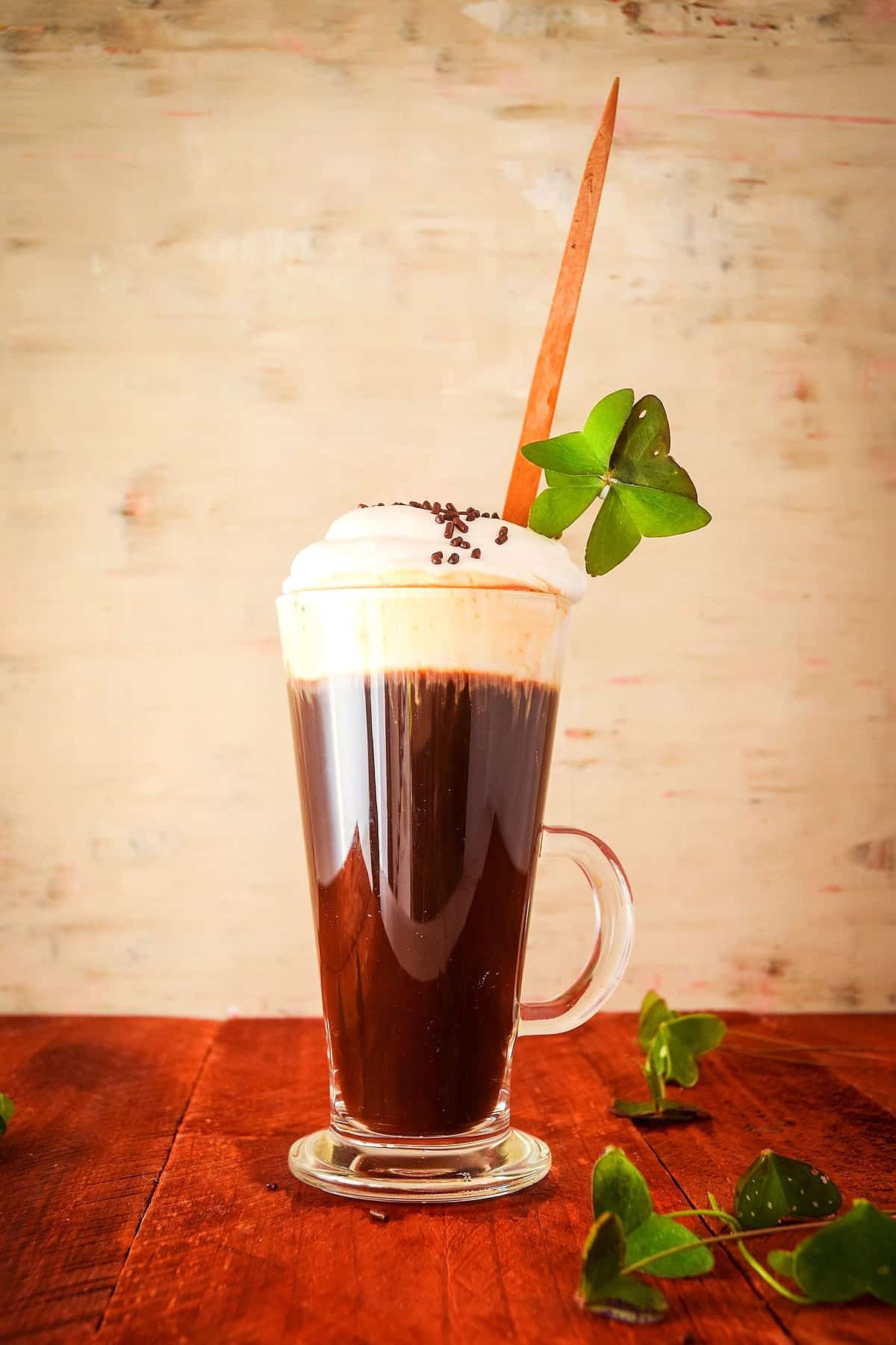 Irish coffee with 4 leaf clover in Irish coffee mug.