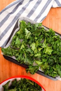 Kale pieces on parchment-lined sheet pan.