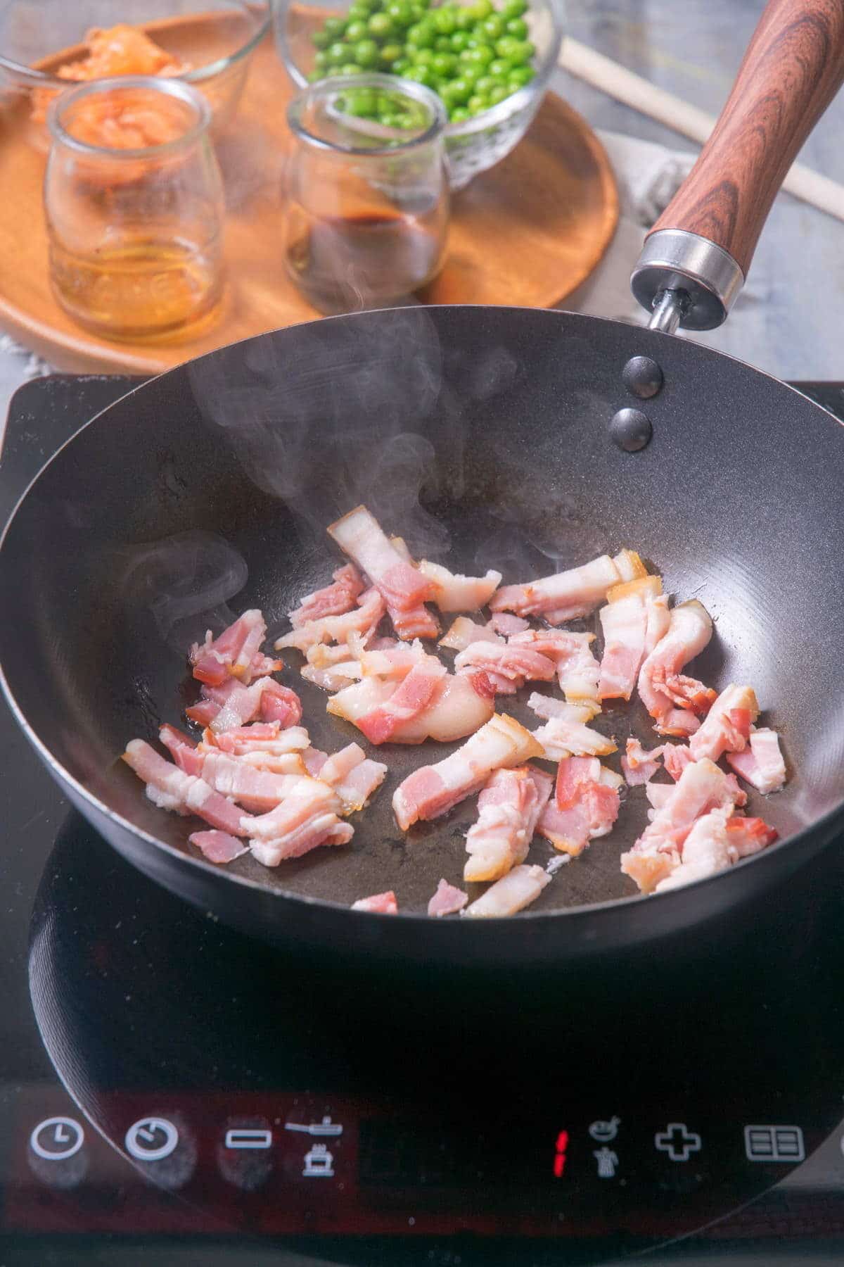 Chopped raw bacon in frying pan.