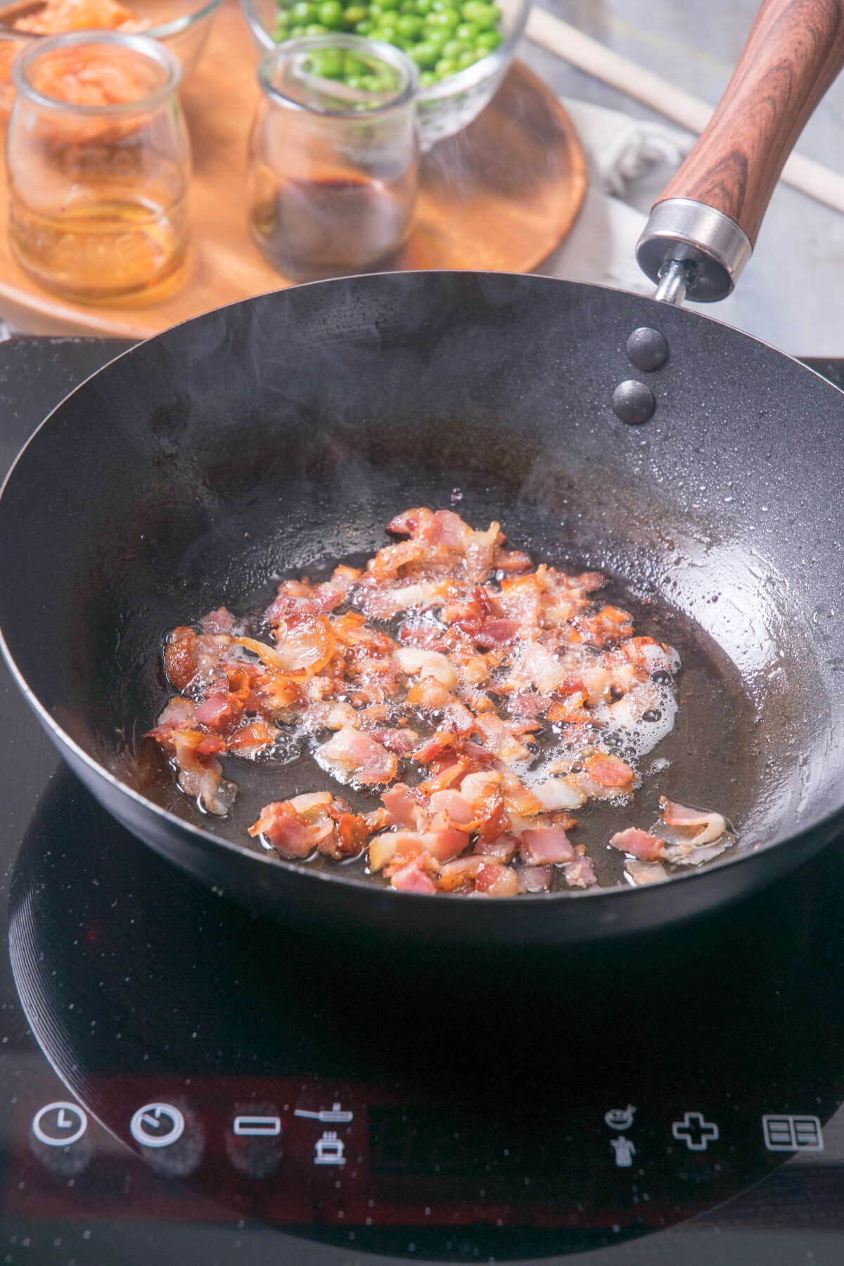 Chopped, golden bacon in frying pan.