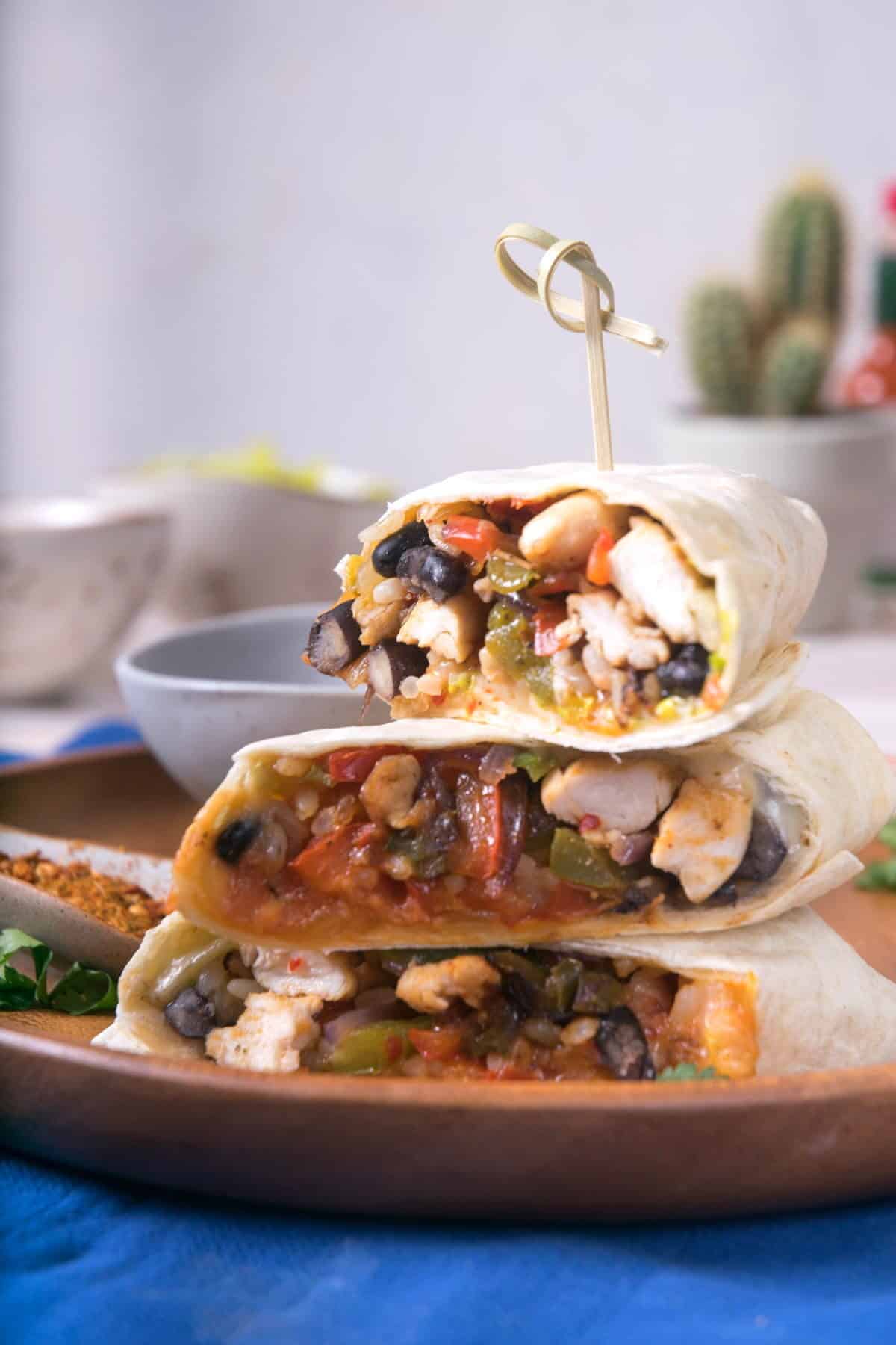Kimchi burritos sliced and stacked on serving tray with toothpick.