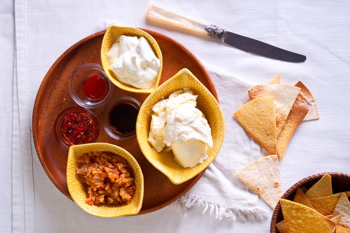 Kimchi cream cheese spread ingredients prepped on wooden plate.