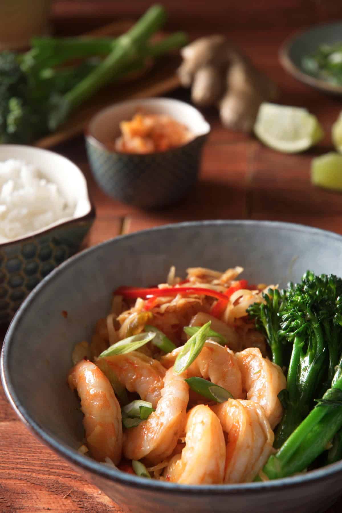 Kimchi shrimp with stir fried broccolini, cabbage and red bell pepper in bowl.