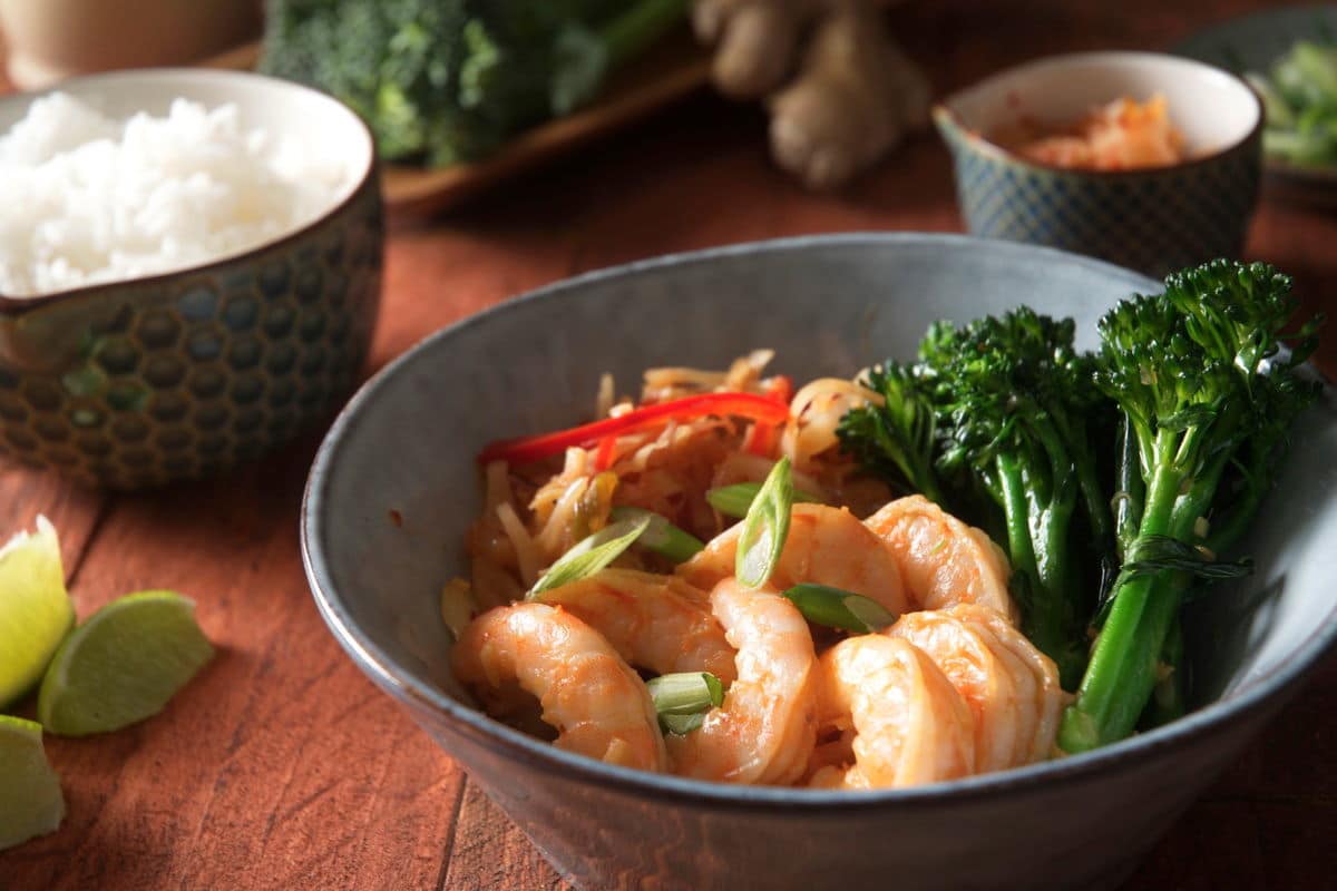 Kimchi shrimp stir fry over rice in a bowl.