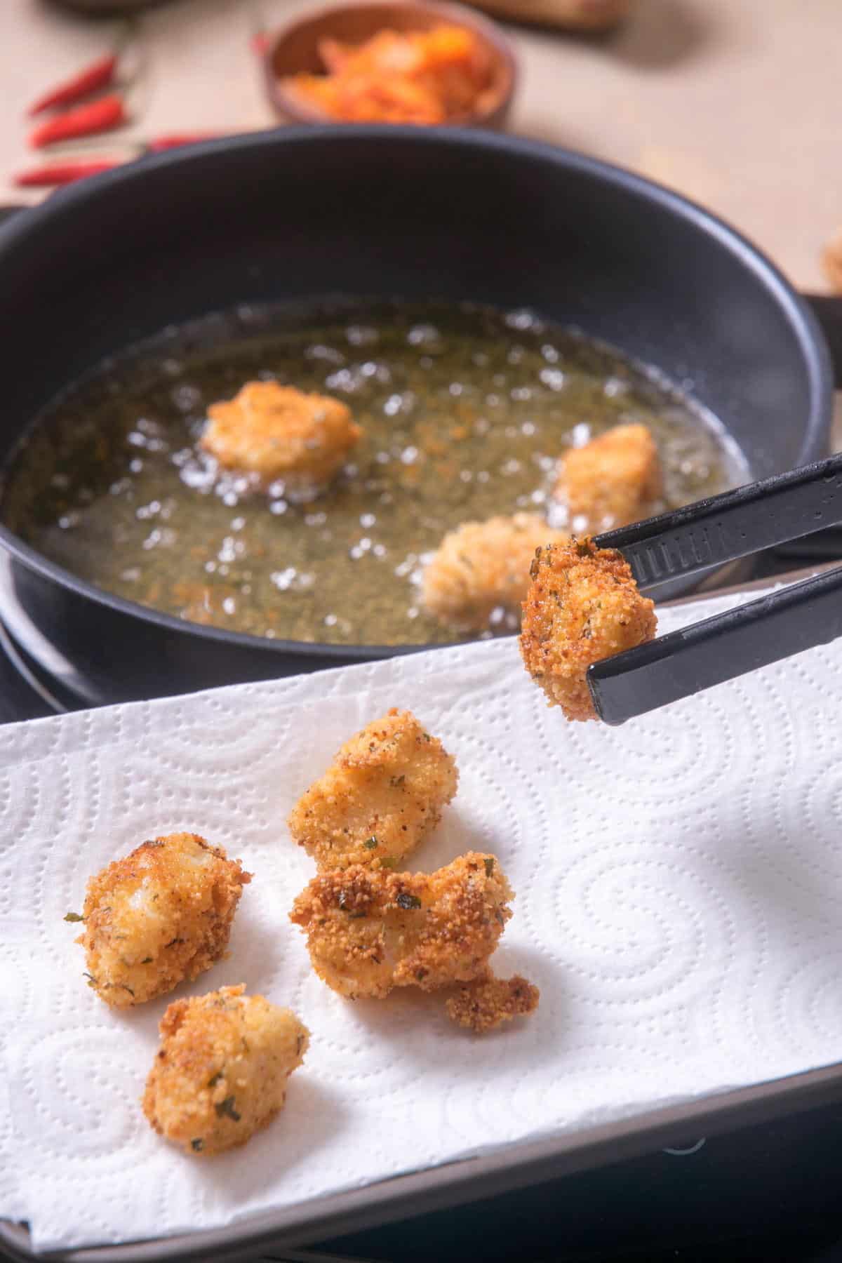 Fried, breaded cod pieces on a paper towel.