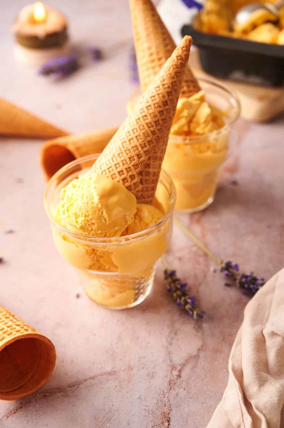 Mac and cheese ice cream in an ice cream glass with a waffle cone.
