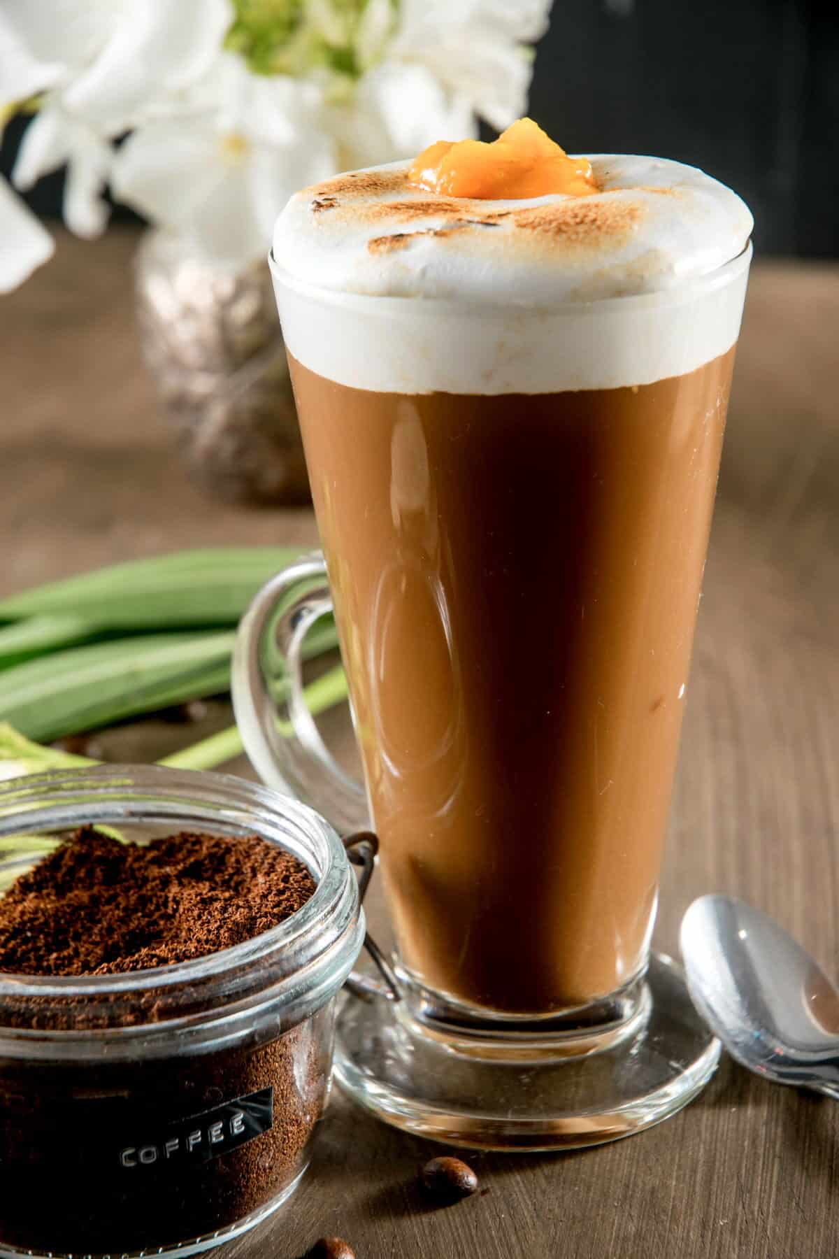 Toasted marshmallow pumpkin latte in a mug with a small amount of pumpkin purée topping.