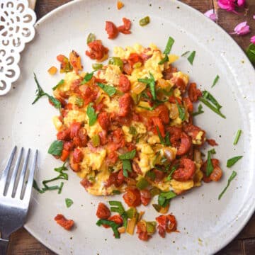 Chorizo and eggs on plate with fork.