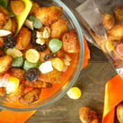 Churro snack mix in a bowl with a yellow scoop.