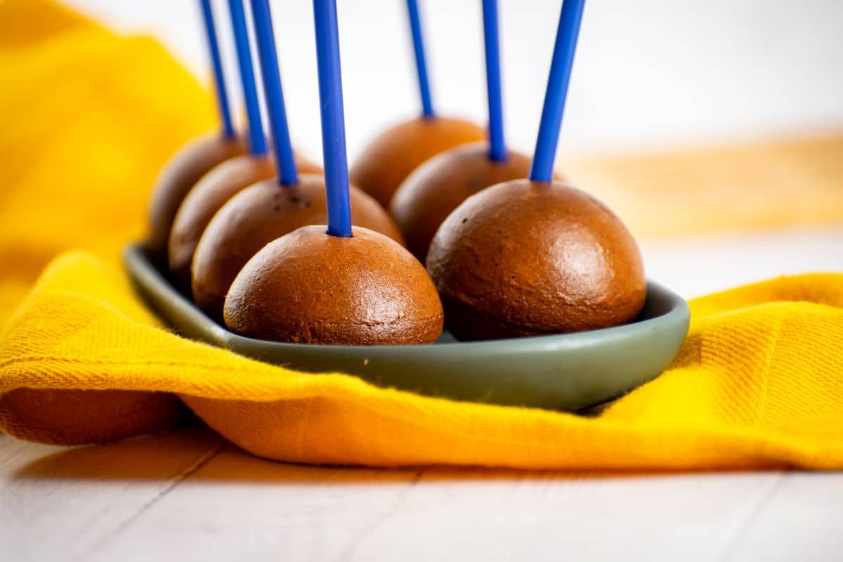 Naked Chocolate Cake Pops in Cake Pop Maker 2 Naked chocolate cake pops on black dish with yellow cloth.