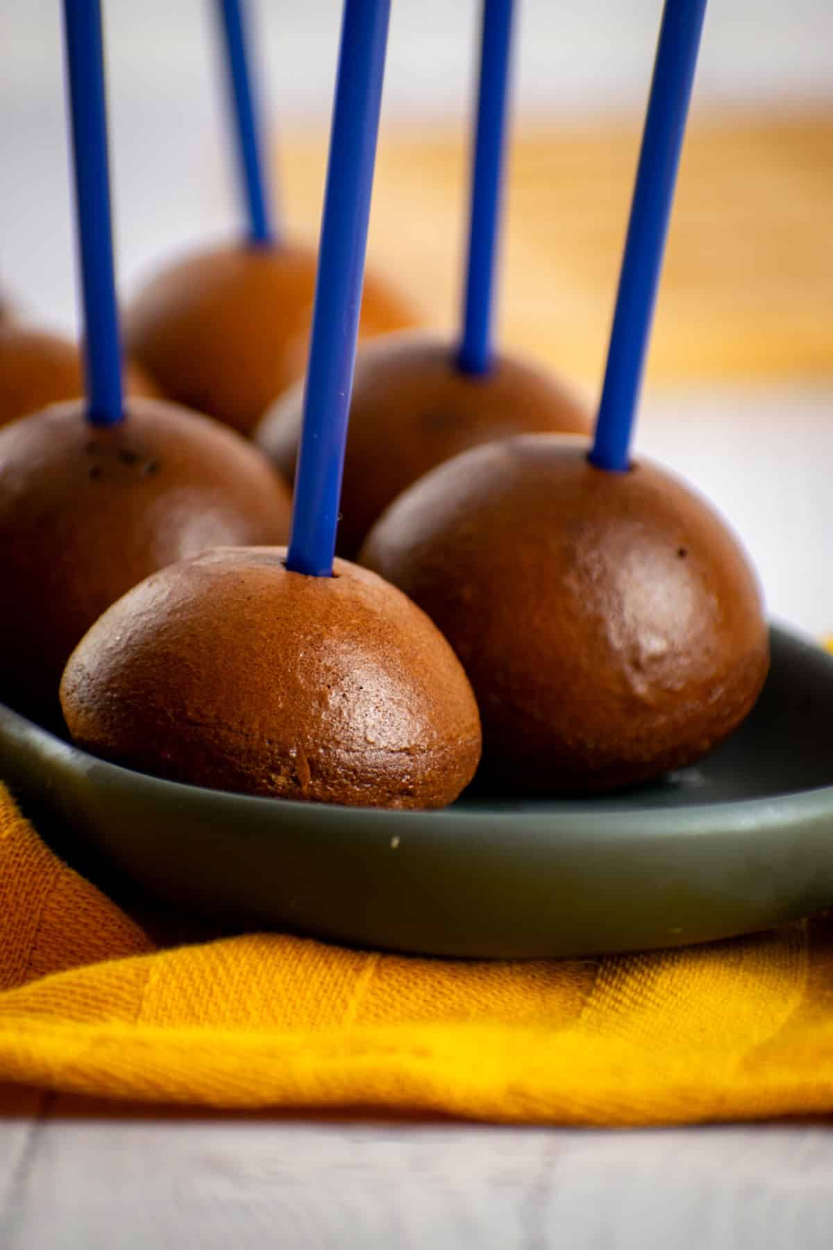 Naked cake pops on black dish with yellow cloth.