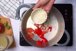 Red bell pepper and onion in pot.