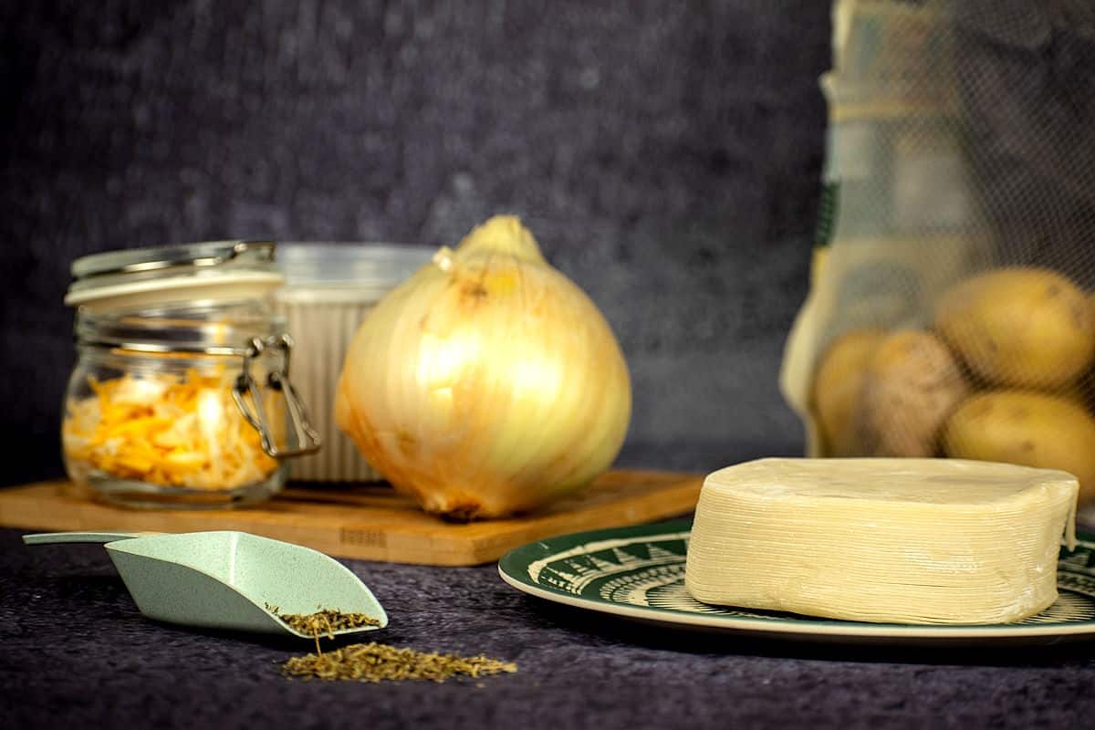 Pierogi ingredients prepped on blue background.