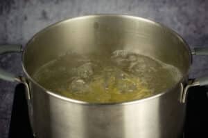 Potatoes boiling in pot of water.