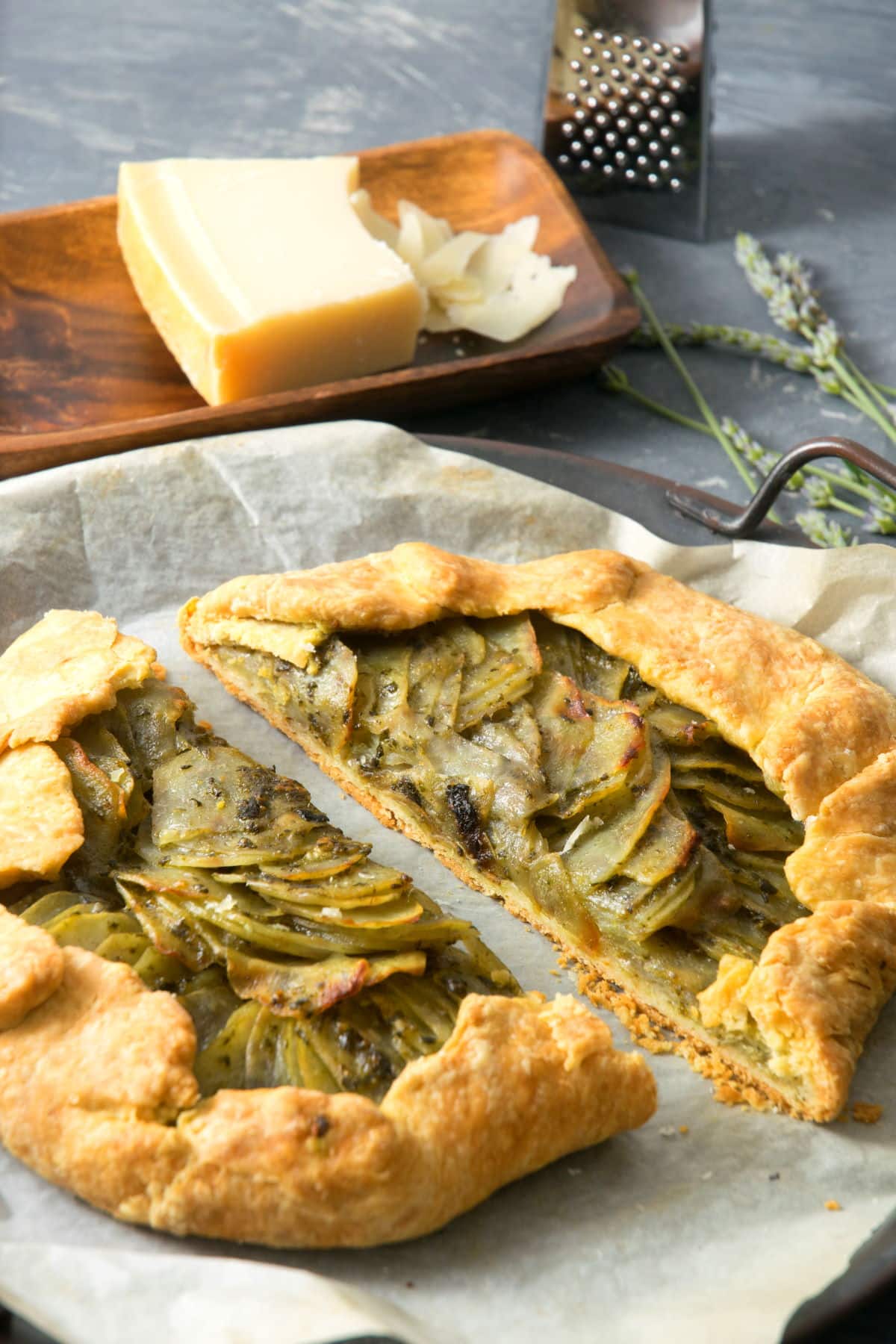 Potato galette sliced in half on parchment paper.
