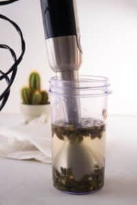 Pumpkin seeds and filtered water in a blender jar.