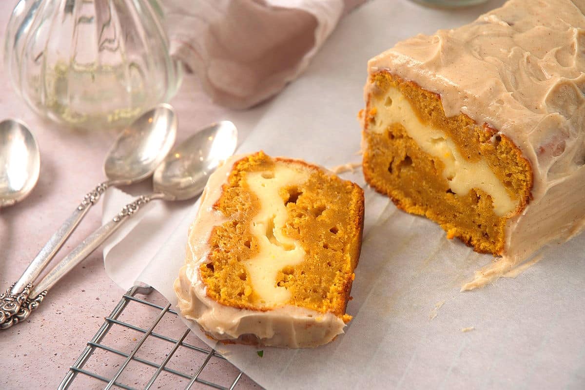 Pumpkin bread sliced open on parchment.