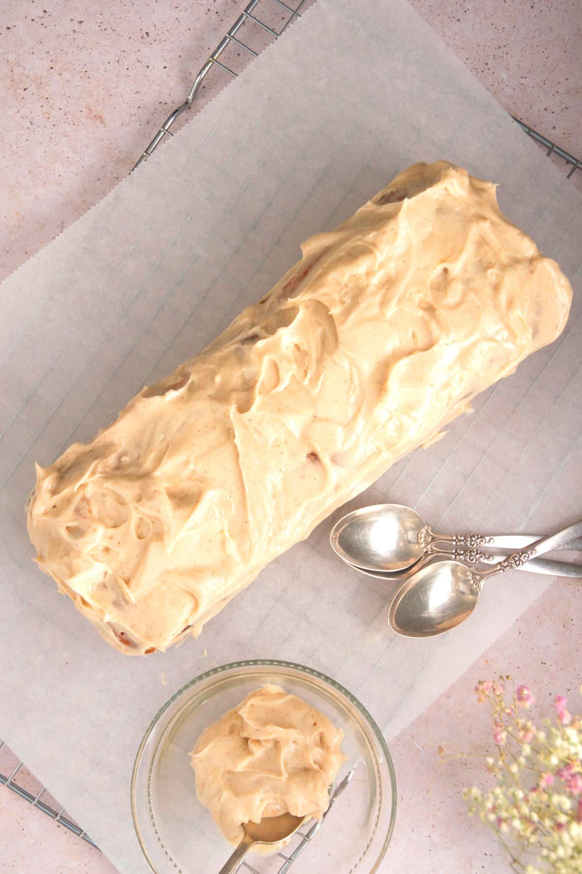 Frosted pumpkin bread on parchment-lined baking rack.