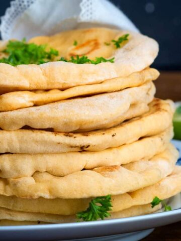 Pumpkin naan bread stacked on a decorative plate.