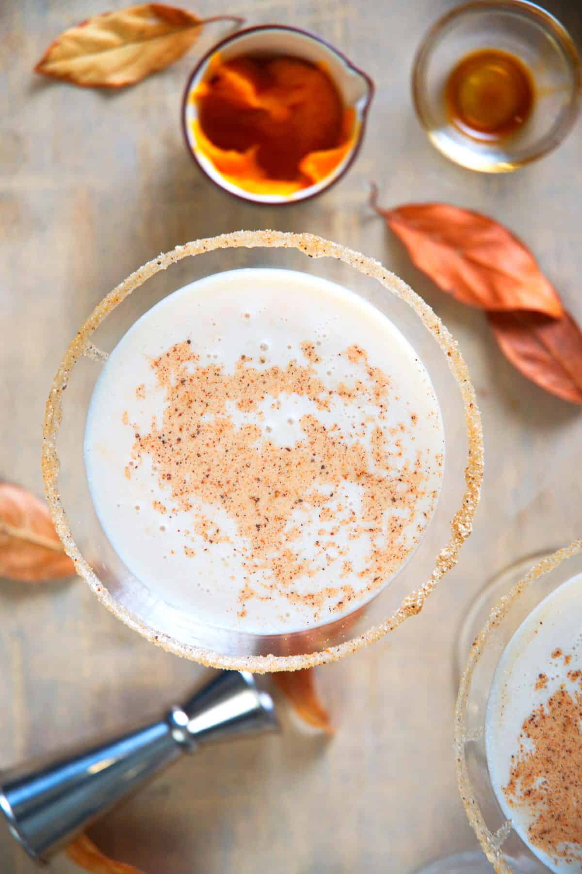 Pumpkin martini with orange leaves surrounding the drink.