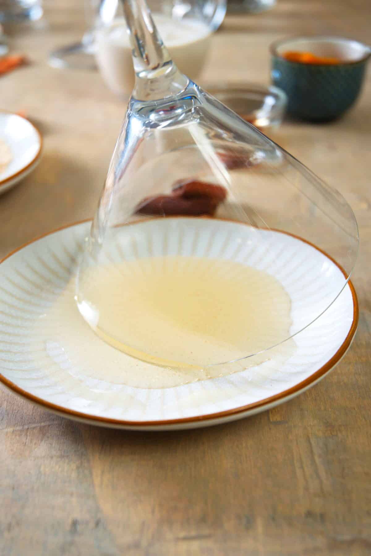 Martini glass dipped in plate of syrup.