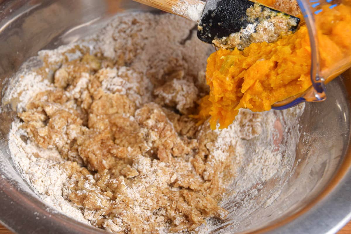Pumpkin muffin batter ingredients in a bowl.