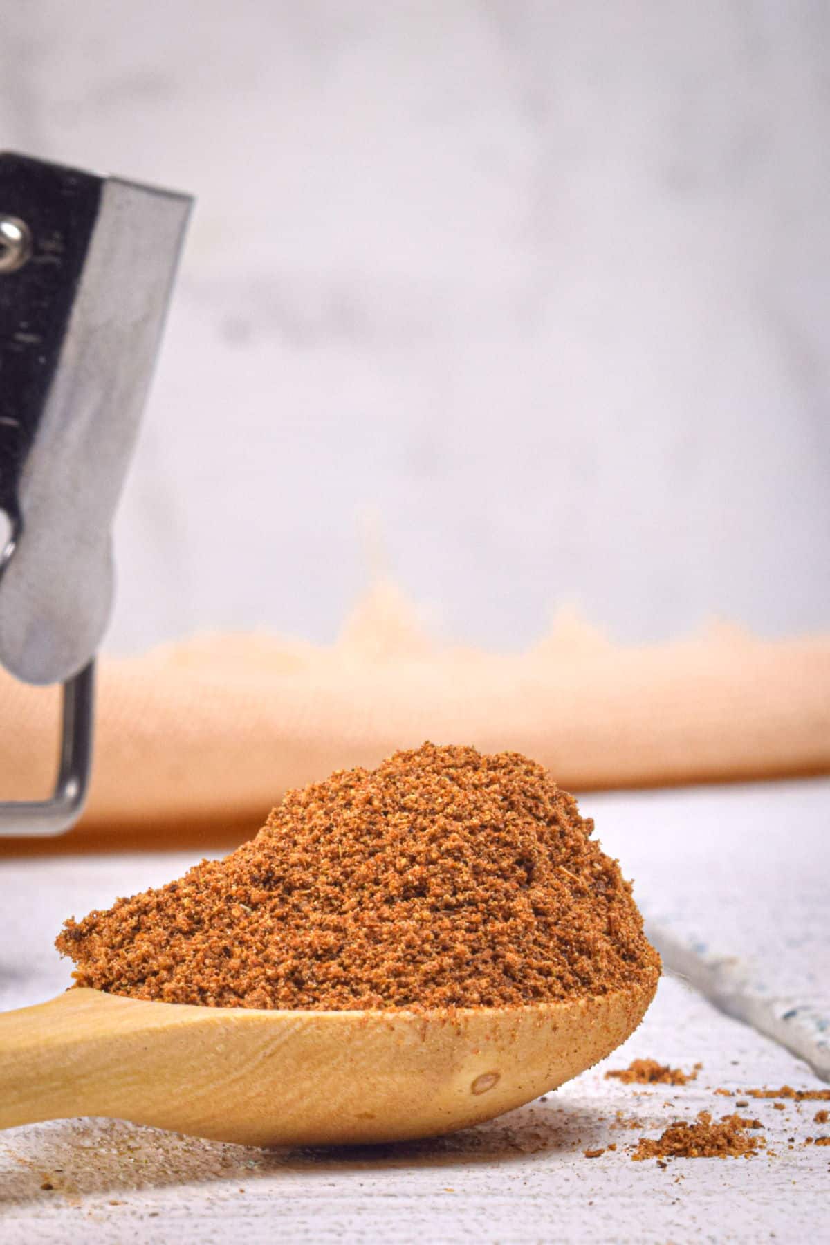 Pumpkin pie spice mix on wooden spoon.